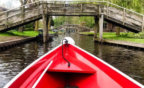 Boat sliding through scenic boat ways of Giethoorn